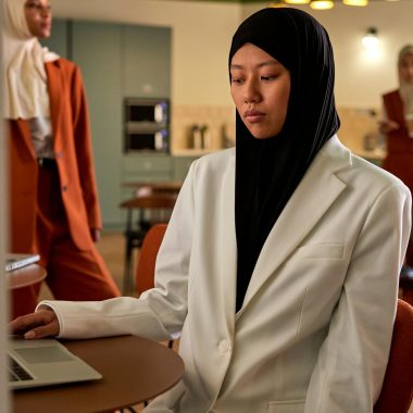 Group of diverse women in hijabs working together in a modern office environment.